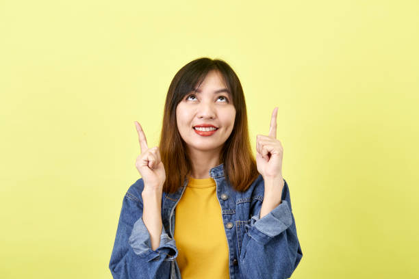 istock Young Asian woman pointing hands on yellow background 1280106797