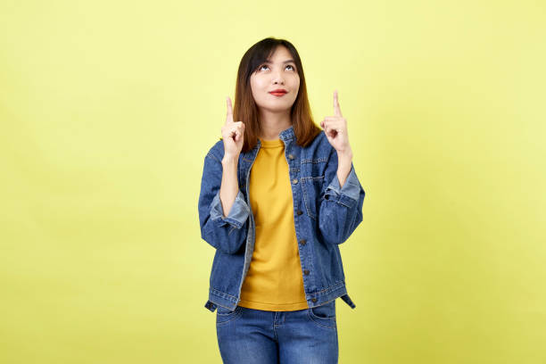 istock Young Asian woman pointing hands on yellow background 1280106799