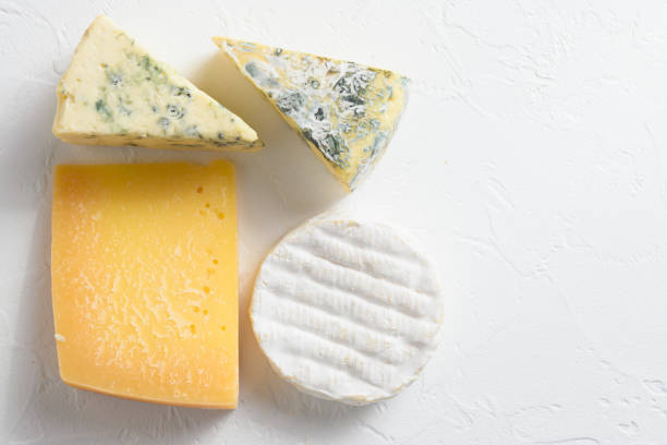 istock Cheese platter: yellow Maasdam, white Camembert and blue cheese Dor Blue  on white background. Copy space.  Concept serving cheese. Top view 1280106808