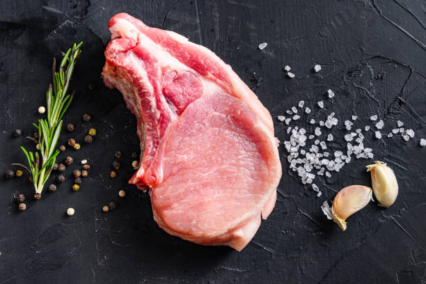 뼈 또는 돼지 고기 배 신선한 생 고기에 유기농 잘라 향신료와 로즈마리와 검은 슬레이트 상단 보기에 고추. - pork chop 이미지 뉴스 사진 이미지