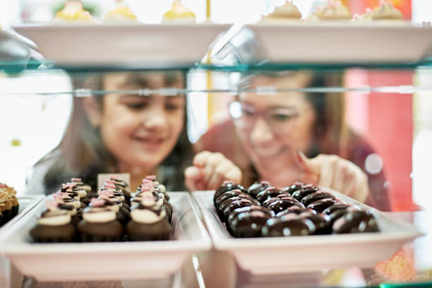 istock Customers Looking at Gourmet Cupcakes in Retail Display 1280107686