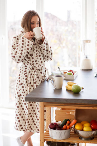 istock Young woman taking a sip of coffee before having breakfast 1280108049