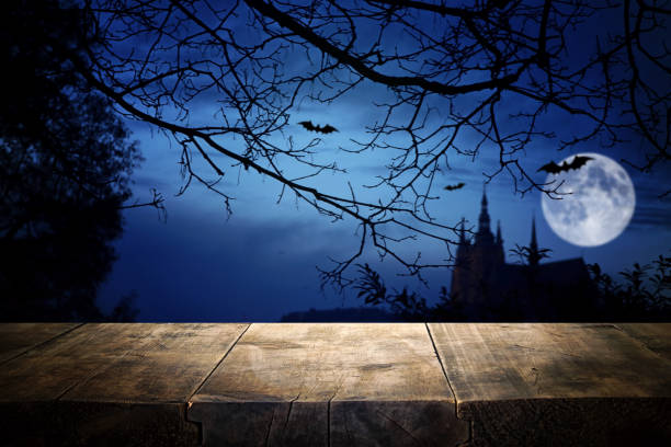 istock Halloween Holiday concept. Empty rustic table in front of scary night sky, forest and full moon background. Ready for product display montage 1280109900