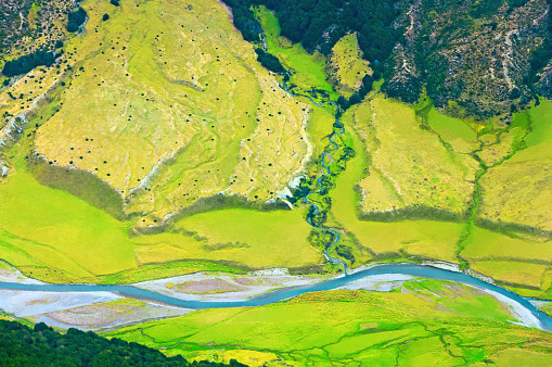 Yellow and green valley with river running through grassland