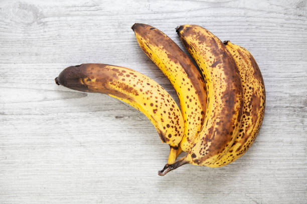 istock Old bananas on a grey wooden surface with copy space 1280110218