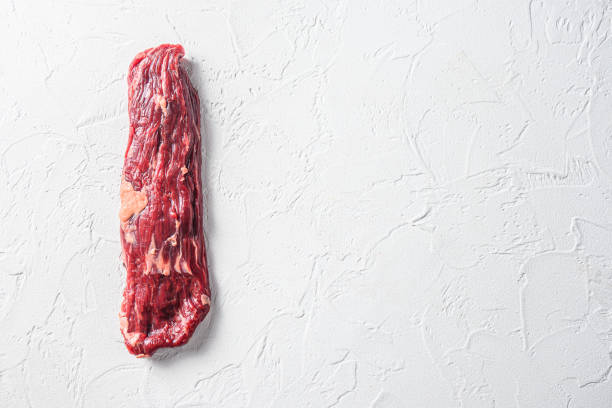 Raw skirt, machete steak on a white stone background space for text.
