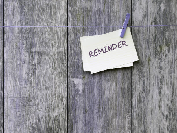 istock Small note with reminder written hung with clothespin against wooden background 1280114974