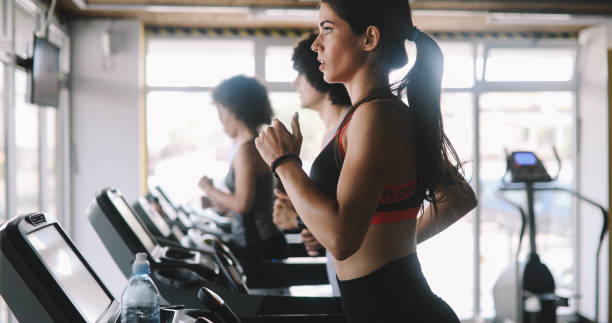 istock Group of young people exercising on a treadmill at gym 1280117531
