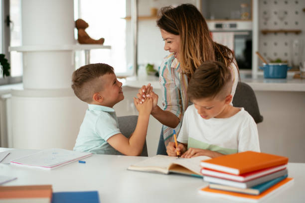 istock Mother helping her son with homework at home. 1280118103