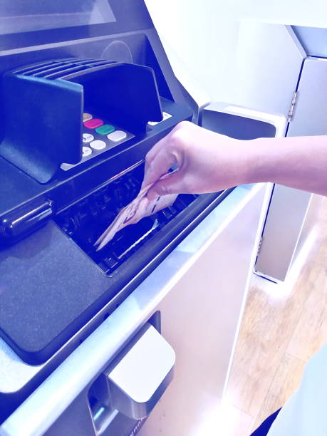 istock female lady using ATM service. woman hand take bank note from ATM service 1280118487