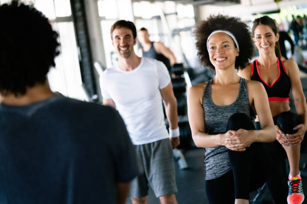 istock Beautiful fit people exercising together in gym 1280118569