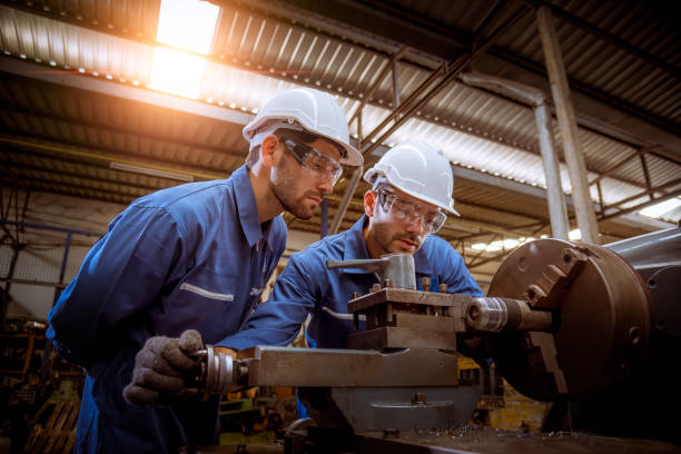 Industry engineering wearing safety uniform control operating lathe grinding machine working in industry factory Industry engineering wearing safety uniform control operating lathe grinding machine working in industry factory machining stock pictures, royalty-free photos & images