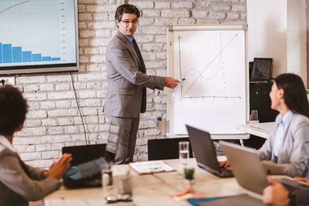istock Senior businessman leading meeting at boardroom table. 1280122363