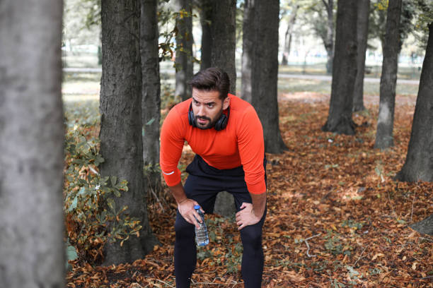 istock A handsome athlete runs, jogs and exercises with headphones in nature 1280125441