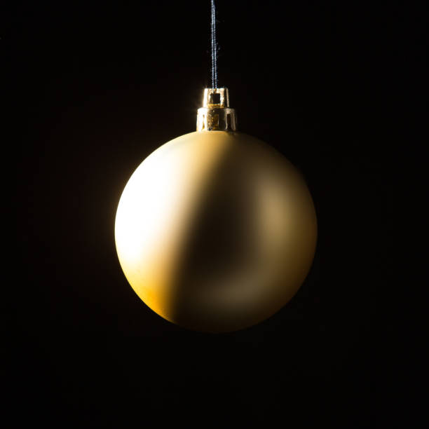 istock Gold Christmas bauble over dark background. Low key photo. Ball shape. 1280126896
