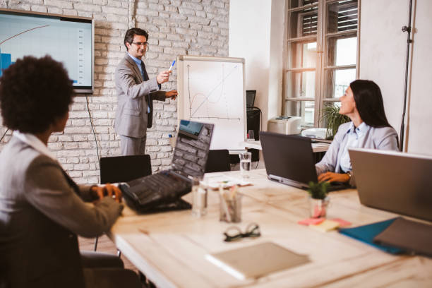 istock Senior businessman leading meeting at boardroom table. 1280127140