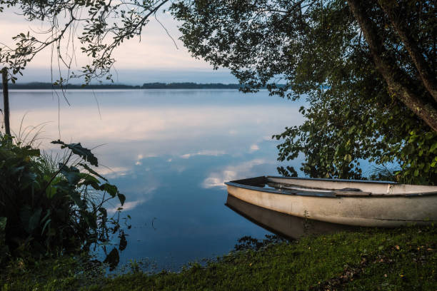 istock landscape with a small sailboat by a lake at dawn 1280127155