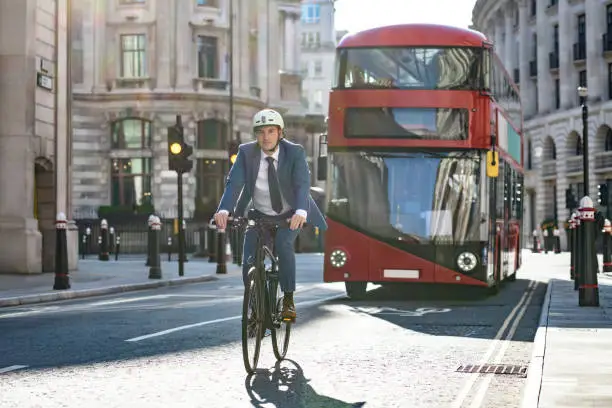 Photo of Mid adult male executive cycling to work in City of London