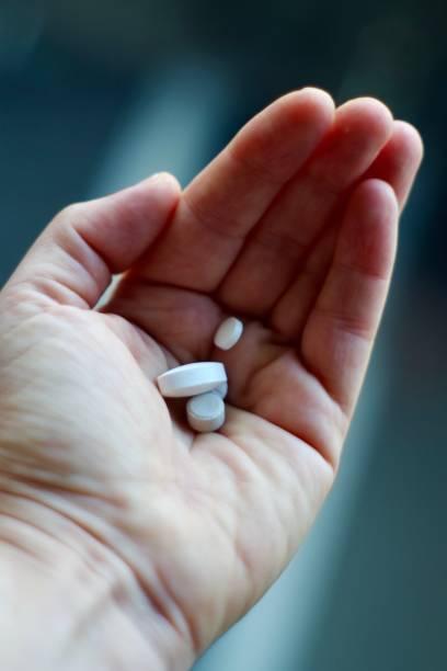 istock Hand holding a mixture of white pills 1280129148