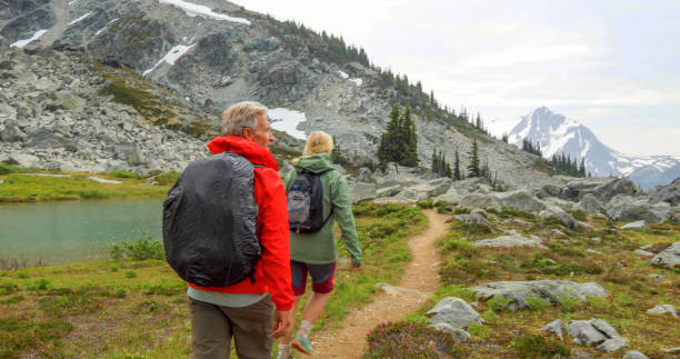 istock Couple hike through alpine meadow in the mountains 1280131397