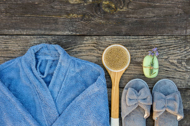 istock Spa day concept. Spa and wellness setting with bathrobe, brush, soap with lavender scent, slippers 1280132846