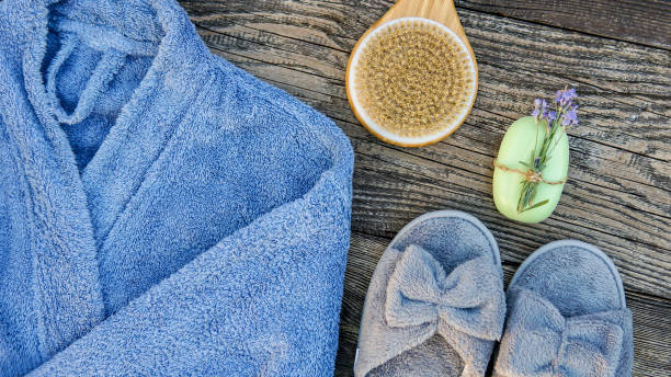 istock Spa day concept. Spa and wellness setting with bathrobe, brush, soap with lavender scent, slippers 1280132905