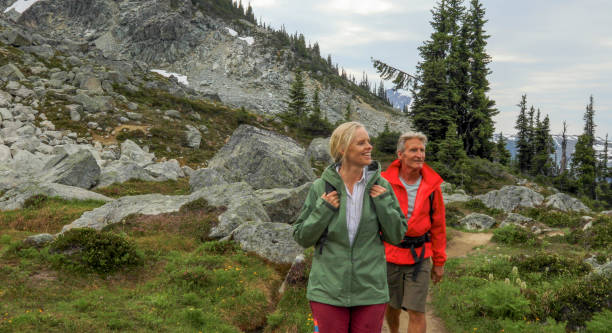 istock Couple hike through alpine meadow in the mountains 1280133273