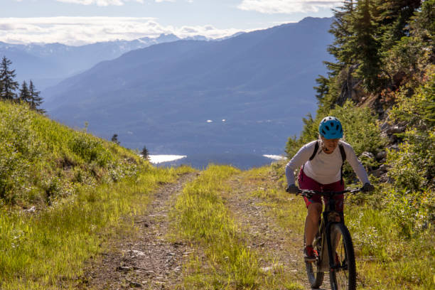 istock Female mountain e-biker rides up alpine road 1280135048
