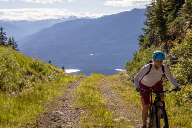istock Female mountain e-biker rides up alpine road 1280135159
