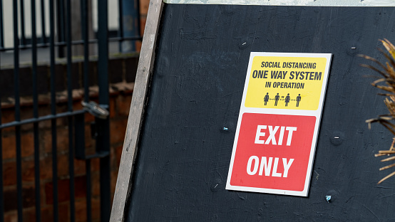Social distancing exit only sign at a pub during a pandemic