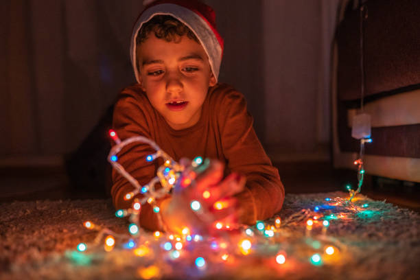 istock Boy playing with Christmas lights at home 1280137394
