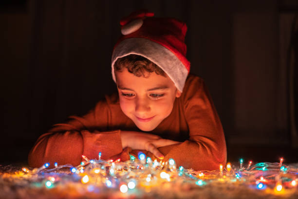 istock Boy playing with Christmas lights at home 1280137459