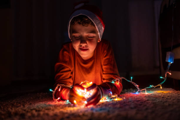 istock Boy playing with Christmas lights at home 1280137492