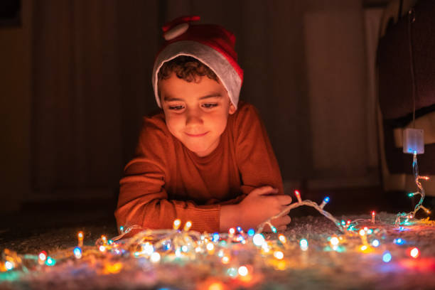 istock Boy playing with Christmas lights at home 1280137509