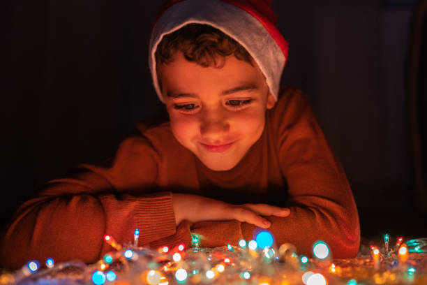 istock Boy playing with Christmas lights at home 1280137661