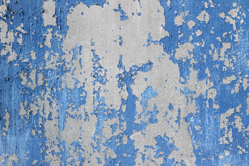 Old Damaged metallic Surface with Peeling Paint Pieces. Blue and silver colors.