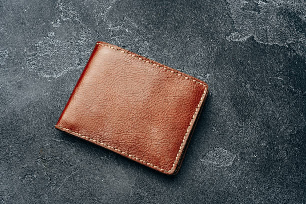 istock New brown leather wallet on dark background 1280138045