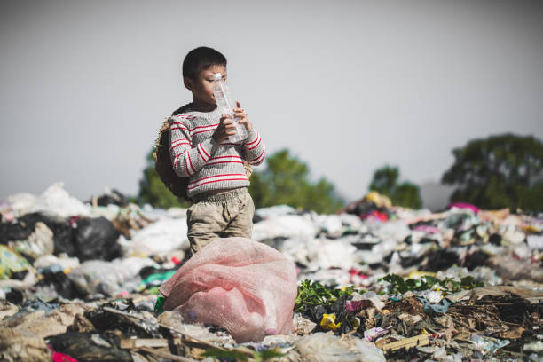 A poor boy collecting garbage waste from a landfill site in the outskirts, the lives and lifestyles of the poor, Child labor, Poverty and Environment Concepts A poor boy collecting garbage waste from a landfill site in the outskirts, the lives and lifestyles of the poor, Child labor, Poverty and Environment Concepts rag picker stock pictures, royalty-free photos & images
