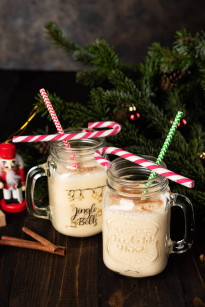 istock Traditional Christmas drink eggnog into glass mug from cocktail shaker. 1280143137