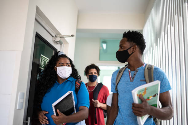 istock Colleagues wearing face mask walking in university / high school's corridor 1280143444