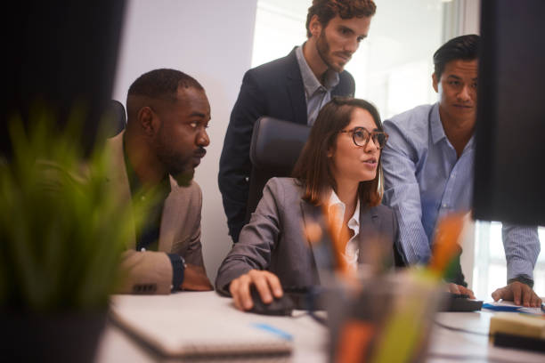 istock Business woman with colleagues looking at computer screen in office 1280146709