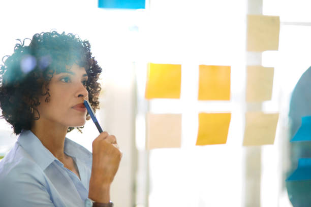 istock Business woman thinking about project on sticky notes in office 1280147597