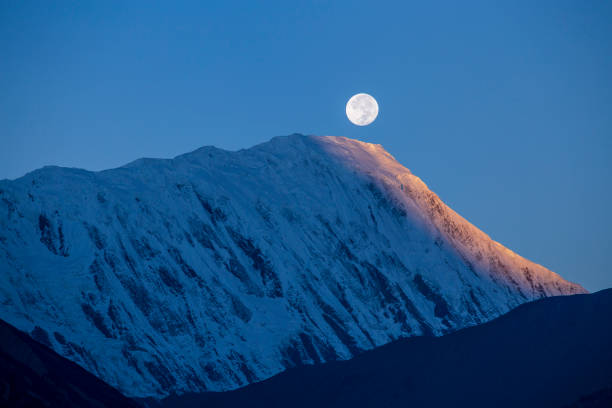 beautiful landscape in himalayas, annapurna region, nepal. full moon during a sunrise on the background of snow-capped mountains - sunrise asia china climbing imagens e fotografias de stock