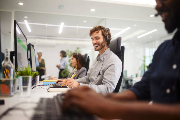 istock Group of customer service call center workers in modern office 1280147793