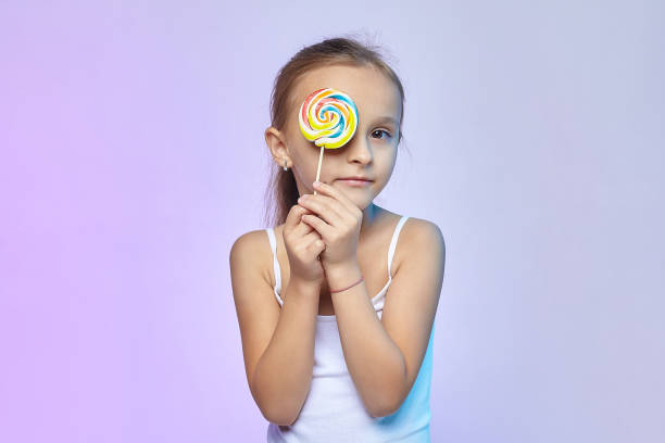 istock a little girl holds a large candy in her hands 1280149781