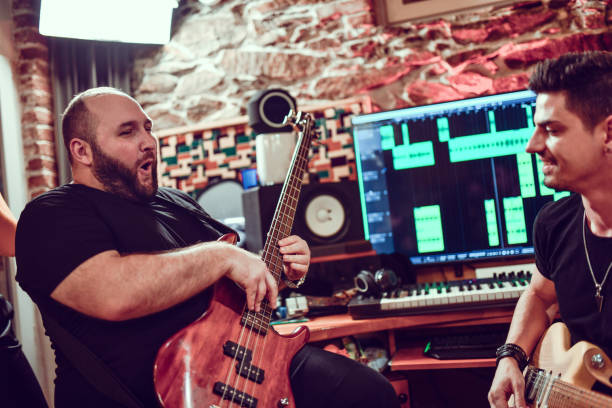 istock Bass Player Excited At Performance With Guitarist In Studio 1280149947