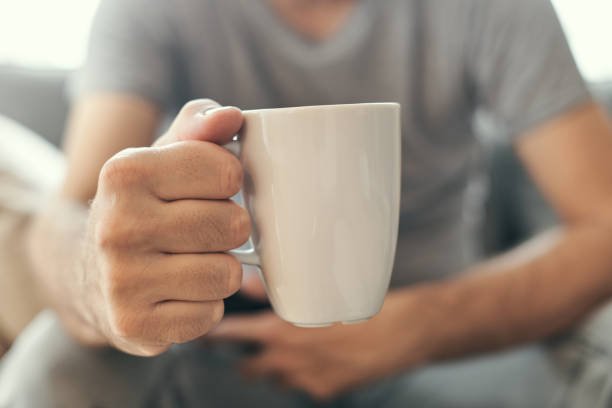 istock Man holding coffee cup in living room 1280150850