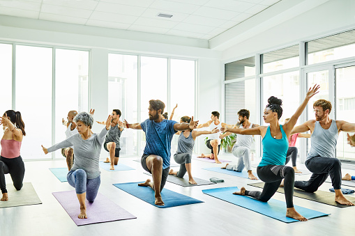 Shot of a group of men and women practicing yoga in a fitness class