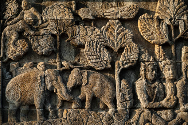Horizontal close-up view of one of the exquisitely ornamented bas-reliefs of Borobudur Buddhist Temple. Borobudur, the World’s largest Buddhist temple, is a 9th century Mahayana Buddhist Temple in Central Java.
