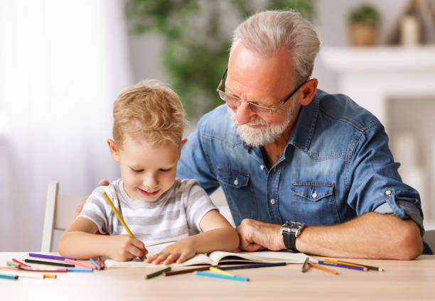 Cheerful boy drawing with grandfather